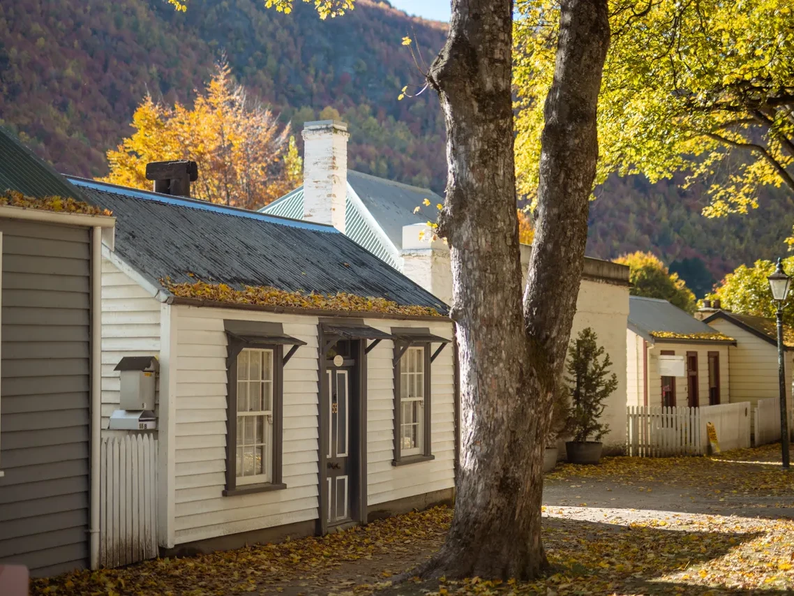 Historic miners’ cottages under golden autumn trees in Arrowtown, near Queenstown